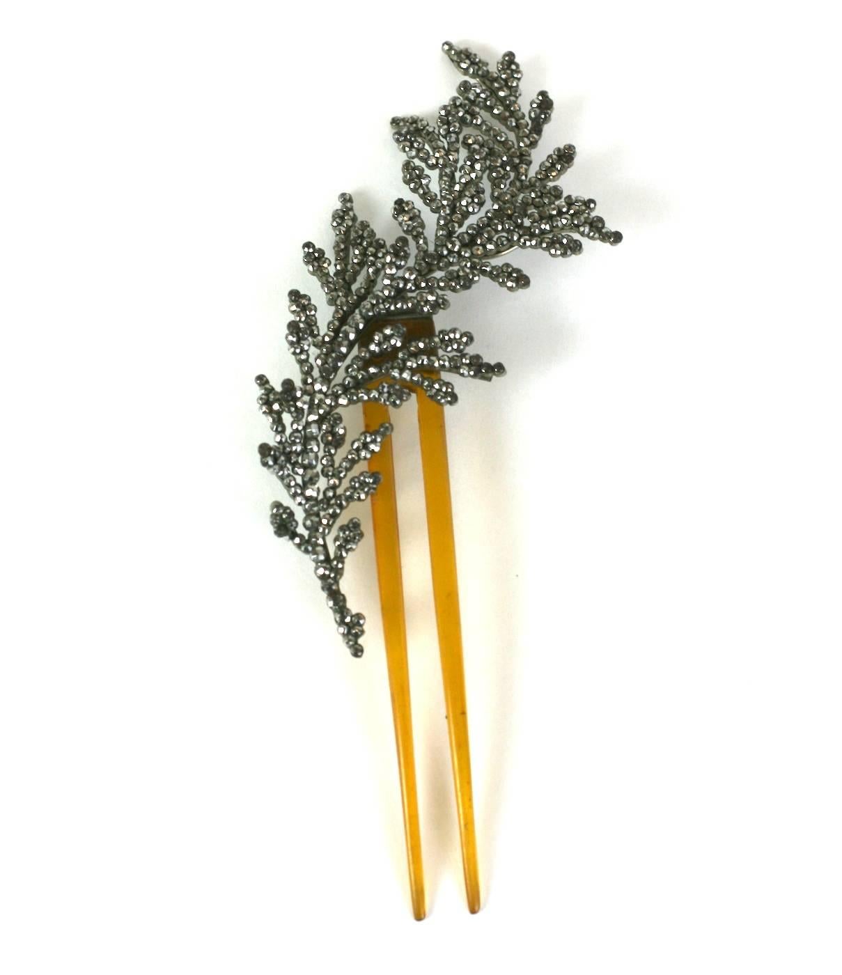 French Cut Steel and blond horn feather comb, the polished steel faceted studs riveted to a steel backing to create the feathers' form, with multiple layers and densely packed studs. The finer and older the piece, the more facets the studs will