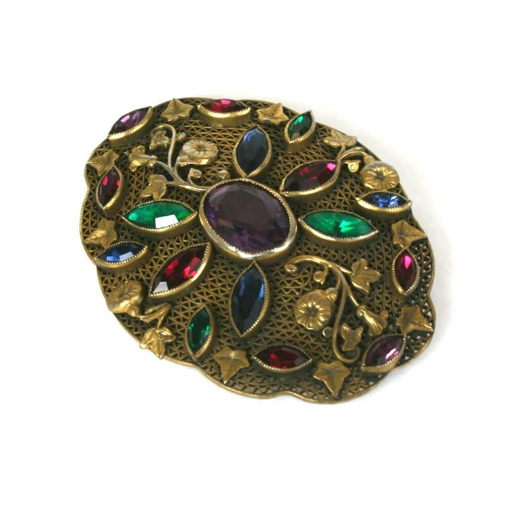 High quality, stone set filigree Czech Brooch from the 1920's. Large in scale with striking bezel set colored pastes and morning glory and ivy motifs. 1920's Czech. 3.25" x 2.5".
Excellent condition. 