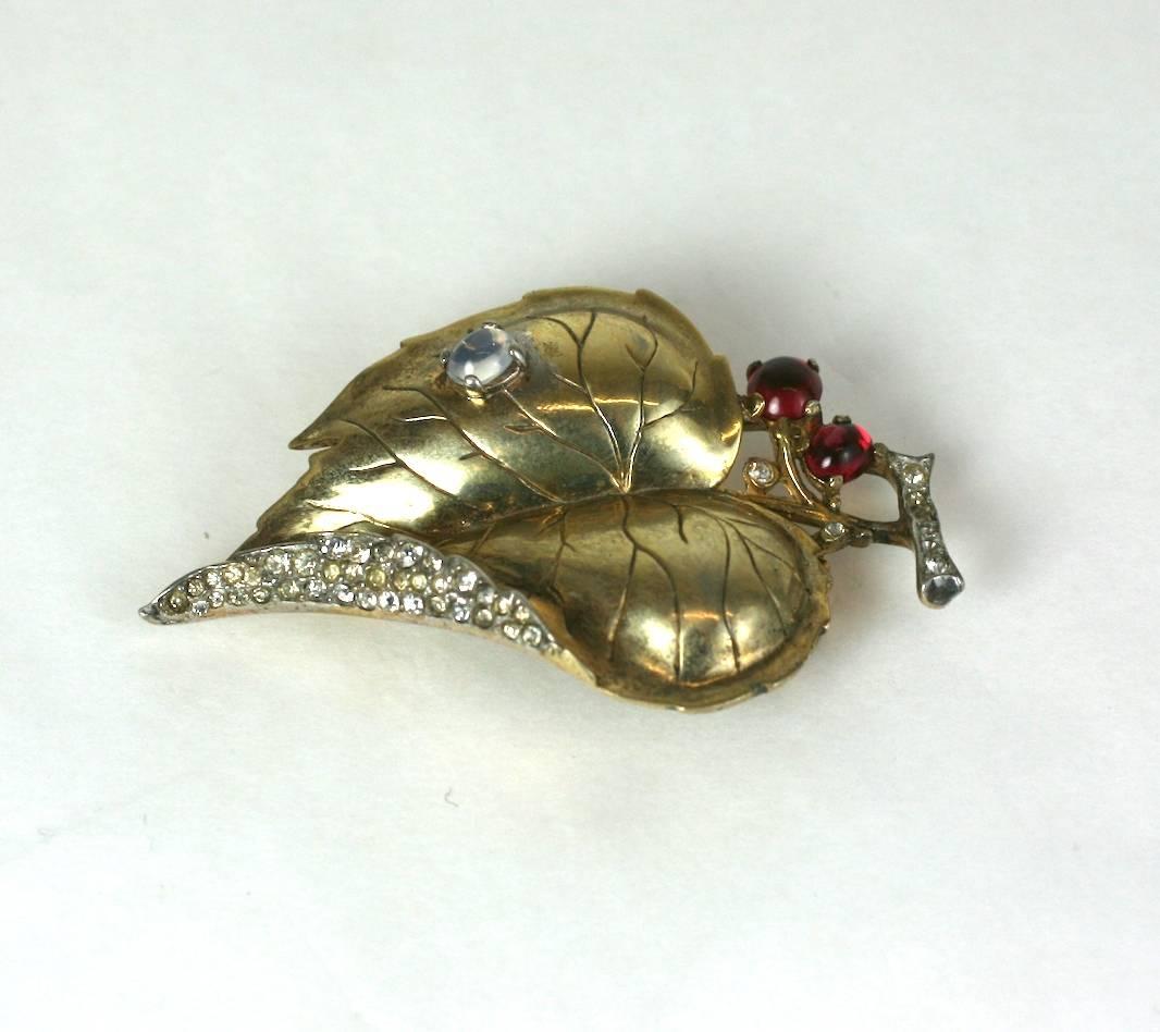 Trifari Alfred Philippe gold washed over sterling  silver 'Dewdrops' moonstone raindrop on gold and pave  leaf clip brooch from the 1940's. Crystal pave, faux moonstone and rubies. 
Excellent Condition.
Length 2.50