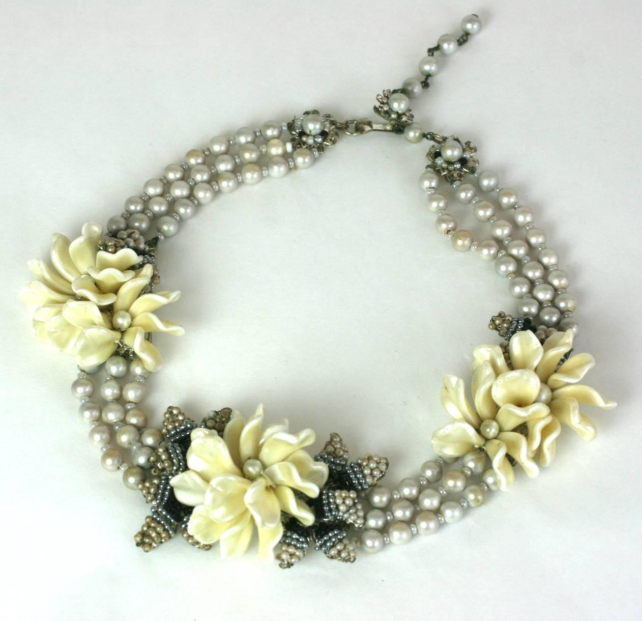Miriam Haskell freshwater faux pearl flower station necklace. Lovely pearlized petals are sewn in stations with contrasting black, grey and seed pearl "leaves", all mounted on signature Haskell silver gilt filigrees. 1950's USA. 
Good