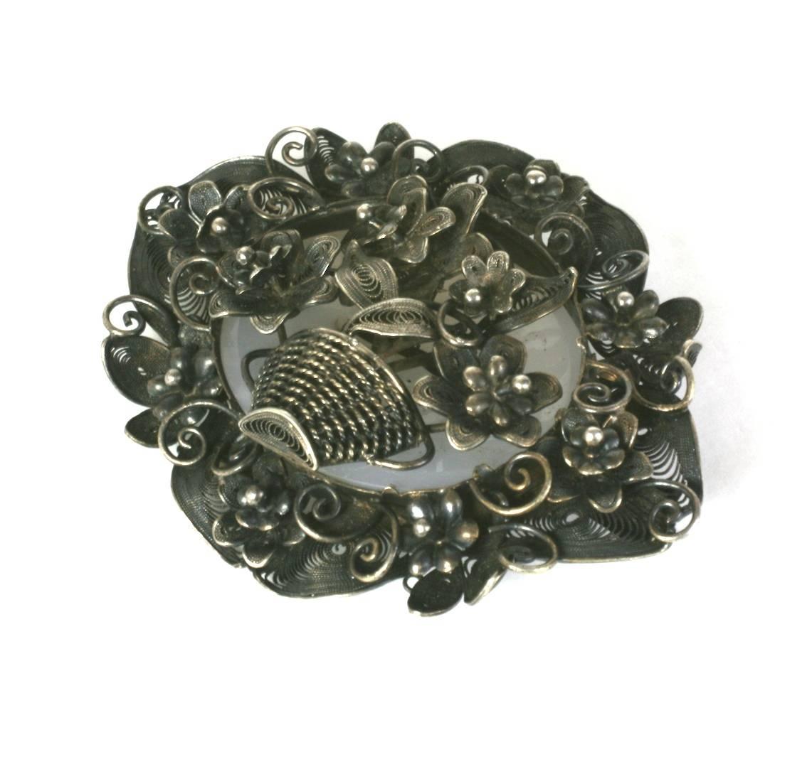 Large Victorian English Sterling silver Filigree Basket Brooch from the late 19th Century. Elaborate wire work forms the central basket motif and the elaborate floral surround. The basket is bolted into a chalcedony oval stone backdrop.  Wonderful