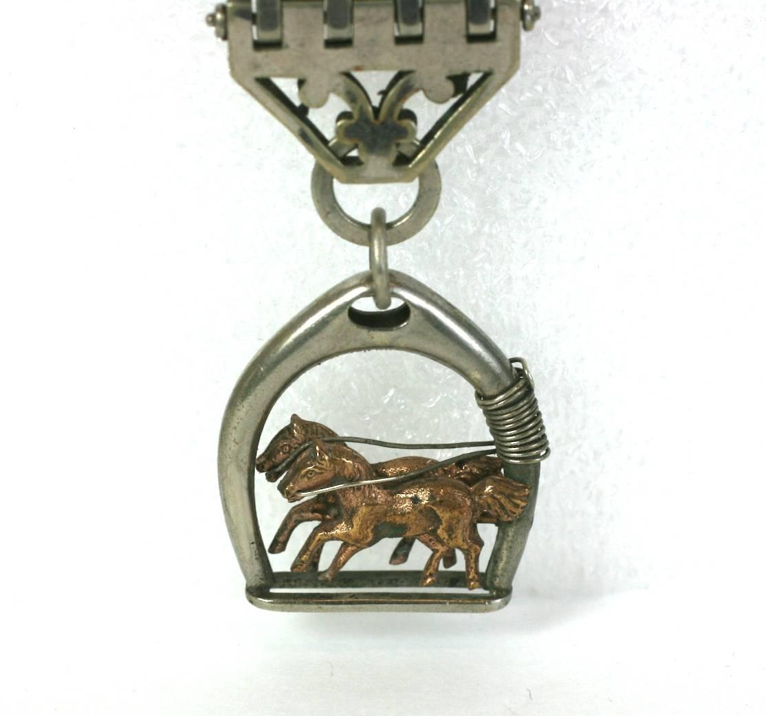 Art Deco Horse Theme Fob from early 20th Century of silvered metal with a pair of galloping horses in rose toned metal within a stirrup motif. 
Excellent condition. 1920's USA. 
5.5" x 1". 