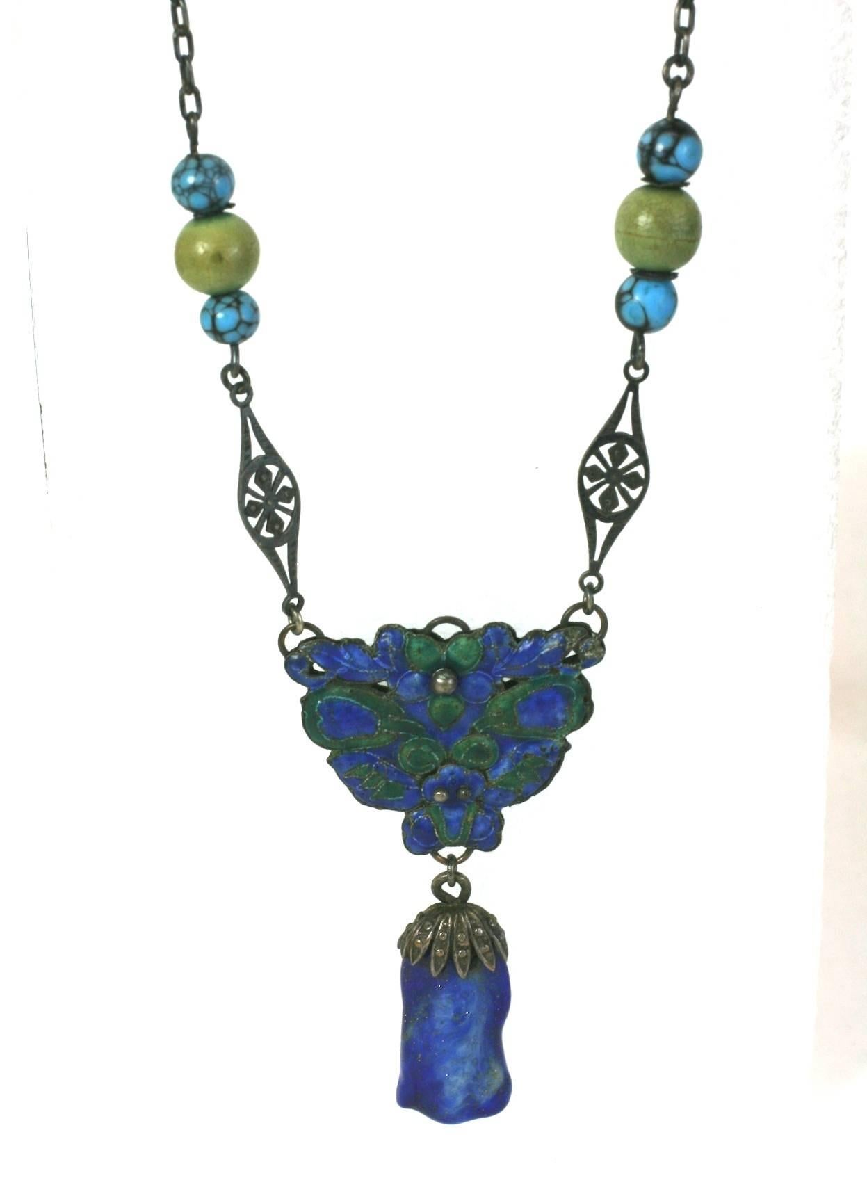 Antica collana cinese in smalto e vetro di lapis in argento del 1900 circa.  Motivo centrale smaltato in verde e blu con goccia di lapis pate de verre. Perline in finto turchese e pietra dura su catena. 
Misura piccola 14