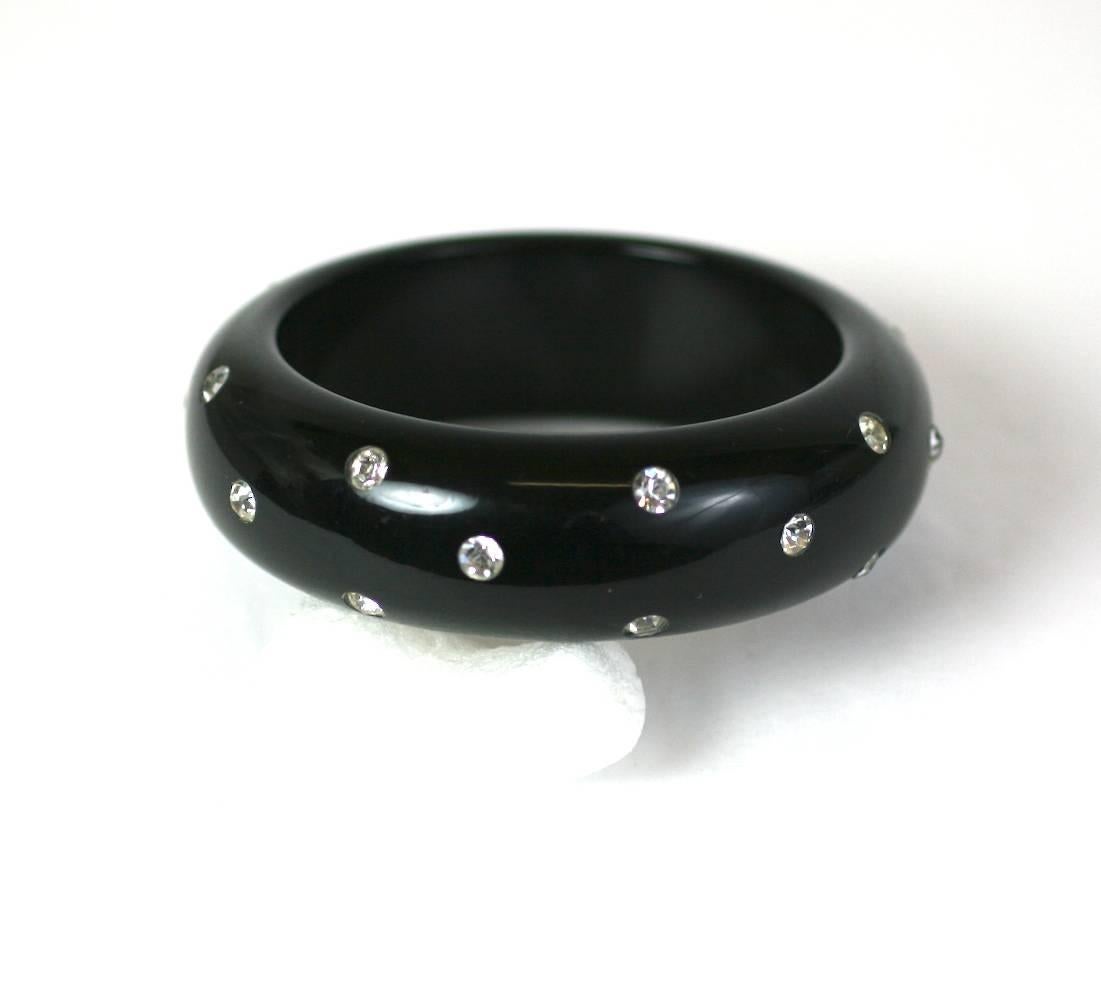Black Bakelite Bangle set with crystals throughout. Nice chunky black bakelite bangle with bright accents. 1950's USA. Excellent condition. 
Interior diameter 2.5