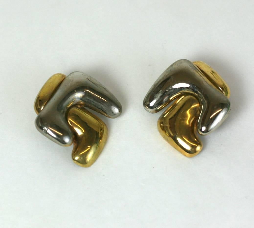 Striking French Modernist ear clips of silvered and gilt metal. Modernist design with sculptural interlocking forms. Imposing in scale. 
Clip back fittings. 1.5" x 2" high. 
1980's France. Excellent condition. 