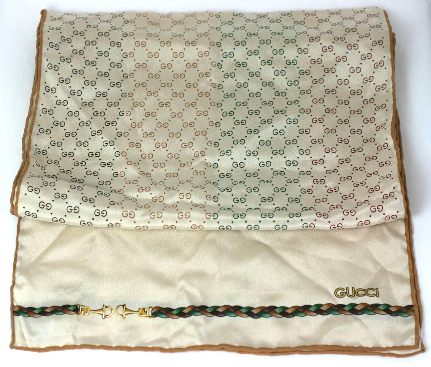 Gucci silk crepe de chine scarf with colorful GG logos in tonal stripes of brown, maroon, and deep green running the length of fabric. 
A braided design with horse bits decorates the ends of the scarf. 1970's Italy.
Hand rolled finishes. Excellent