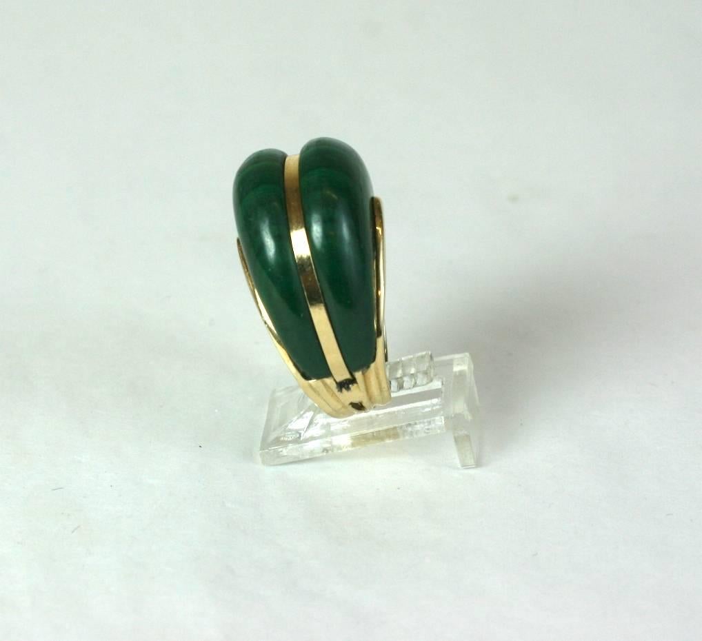 Domed Malachite cocktail ring by Maz, set in 14k gold from the 1970's. Large malachite dome is bisected by a gold band and anchored onto a heavy gold shank. Elegant and timeless 70's jewelry. Signed MAZ, 14k.
Small size 4.5-5 US.  Measure 1.25 in