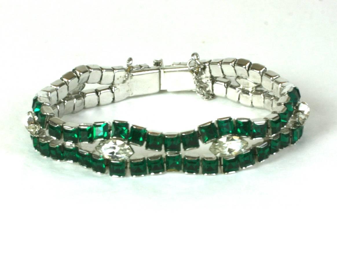 Unusual Deco style bracelet from the 1950's. Classic channel set faux emerald stones are wrapped around 6 marquise shaped crystals. An interesting combination of 1930's and 1950's design elements. Safety chain adds additional security.  7