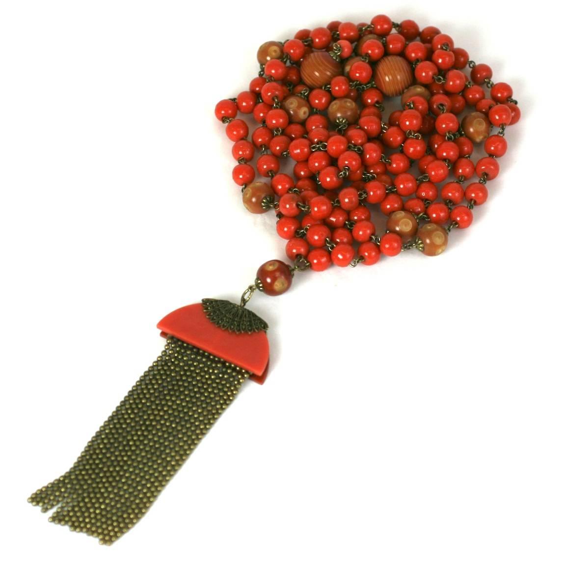 Unusually long flapper beads from the 1920's of orange bakelite with carved and dyed vegetable ivory (plastic). Super long in length, designed to be worn wrapped several times around neck.
A long tassel is formed with bakelite, filigree trim and