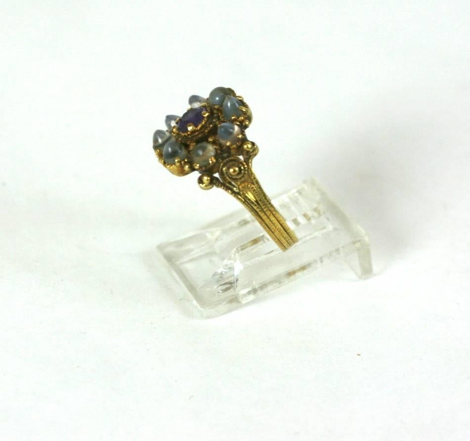Charming Georgian Moonstone Ring from the early 19th Century set in 18k gold. Lovely quality craftsmanship with tiny bullet cabochon moonstones set around a central amythest in closed back settings. 
The shank is particularly special as the