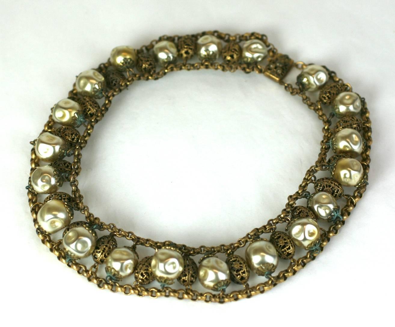Striking, oversized Pearl and Gilt filigreed metal Czech Collar from the 1930's. Hammered finish, hollow glass faux pearls are spaced between gilt filigree beads set on chain. 1930's Czech. 
Excellent Condition.
Length 17"
Width 1 1/8"