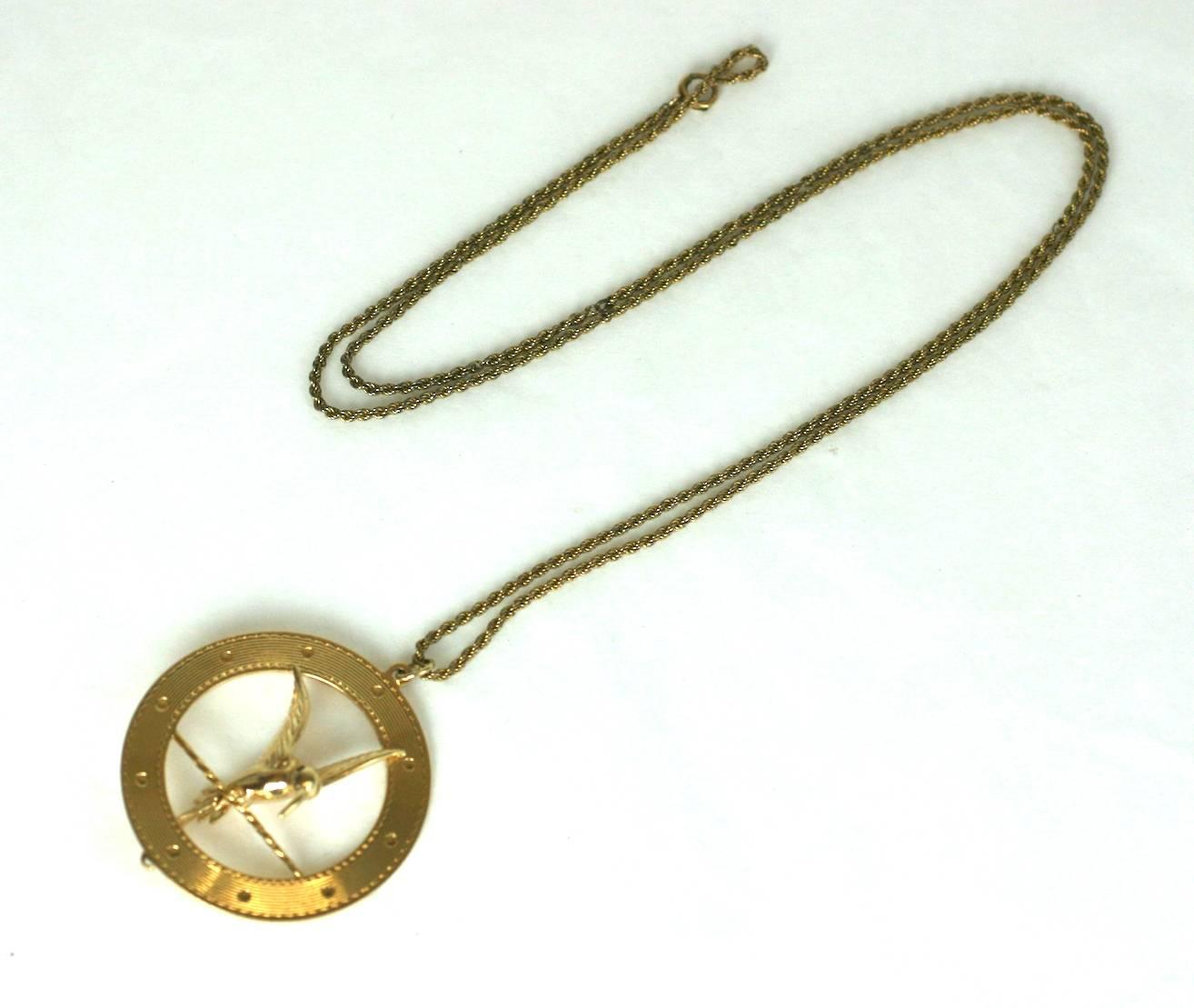 Large, fun gold charm of a Mocking Jay or Hummingbird from the 1950's. Bird is perched on bar in flight mode within a ribbed circle, all rendered in heavy 14k gold with a ruby eye. Well designed with the tip of its tail peeking out below hoop.
Chain
