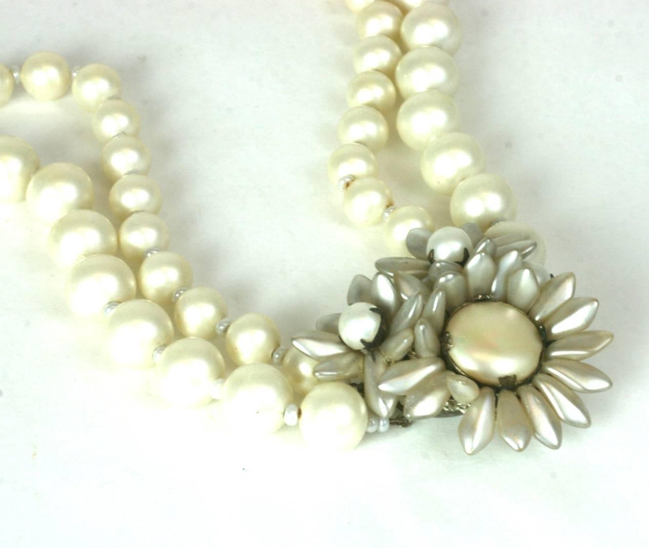 Miriam Haskell signature fresh water faux pearl double strand necklace with decorated center triple Marguerite clasp flower closure. Set in silver gilt  with three  vari-sized flower heads. Excellent Condition. 1950's USA. 
Length 15