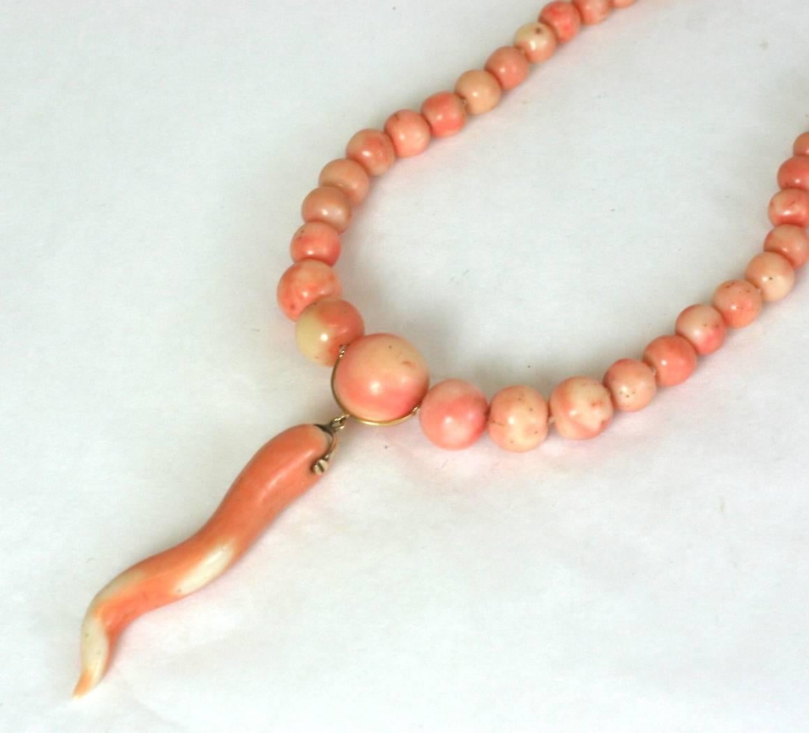 Modern Coral Horn Assemblage of 19th Century elements which have been redesigned for contemporary use. A large natural Victorian angelskin coral horn swings from a genuine strand of graduated angelskin, variegated coral beads.  14K clasp. One of a