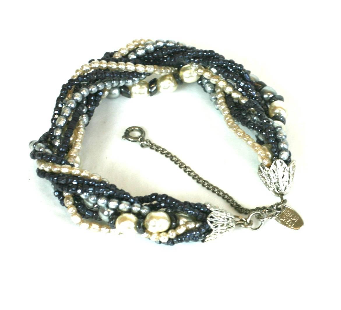 Bracelet Miriam Haskell gris et crème en fausses perles avec des perles de rocaille de jais. Tressé de différentes tailles et couleurs pour un effet dimensionnel intéressant. 
années 50, USA. Chaîne de sécurité également, *' x 1