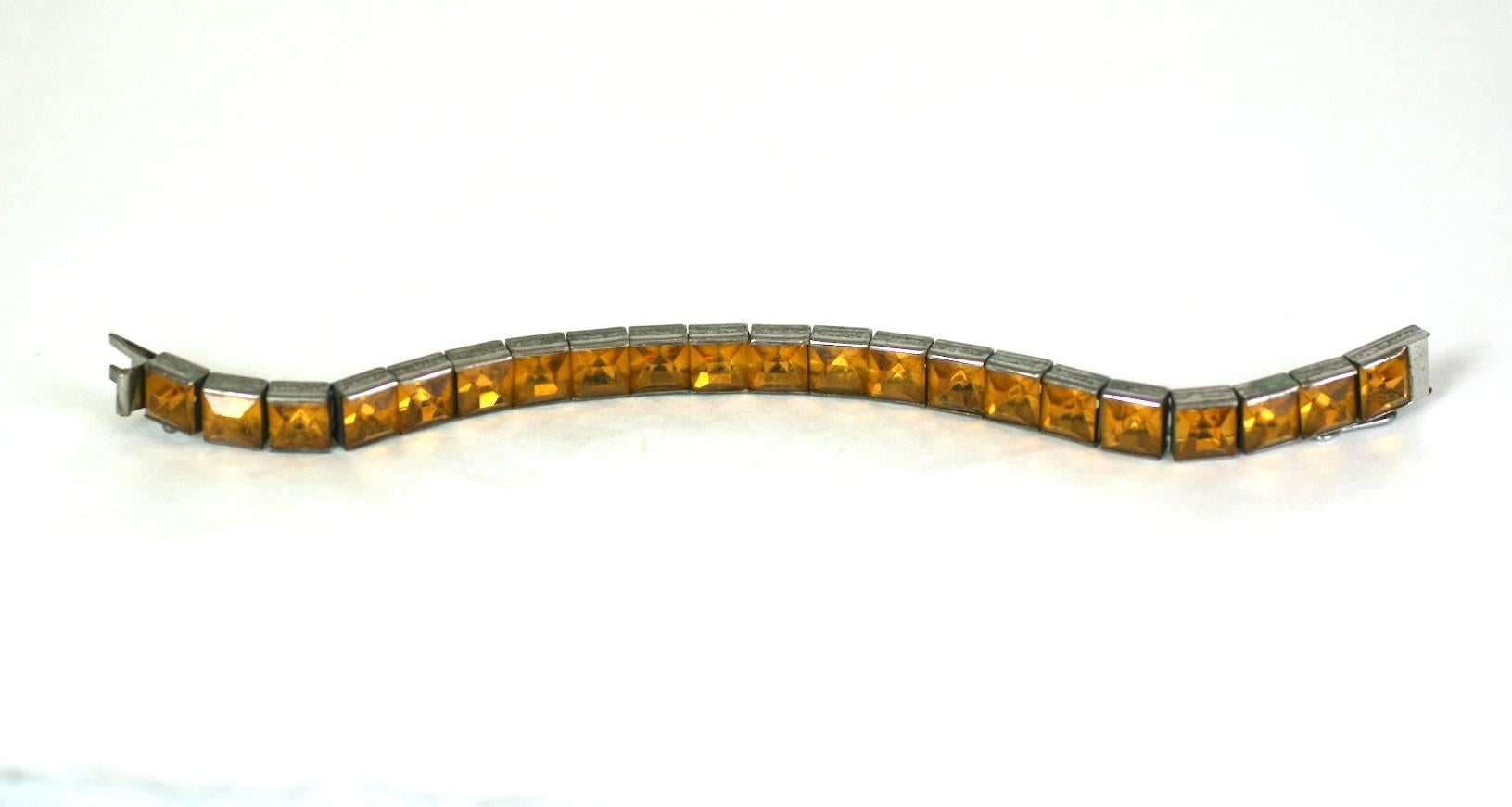 Art Deco Sterling Citrine Straight Line Bracelet from the 1930's. Square cut citrine pastes are set in sterling flexible settings in a tennis style bracelet. Lovely engraved designs on sides of links. 
Wonderfully supple craftmanship. 1920's