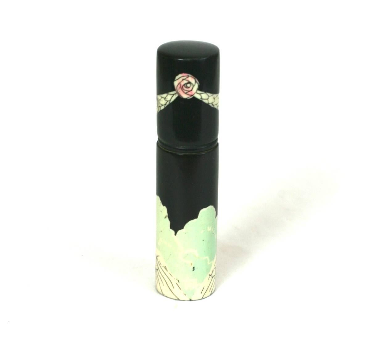 Art Deco French celluloid necessaire, painted black with a flapper in a Robe de Style gown holding a  Poiretesque rose, The interior containing a glass scent holder.  The cover, screw cap closure further decorated with rose and garlands .Made in