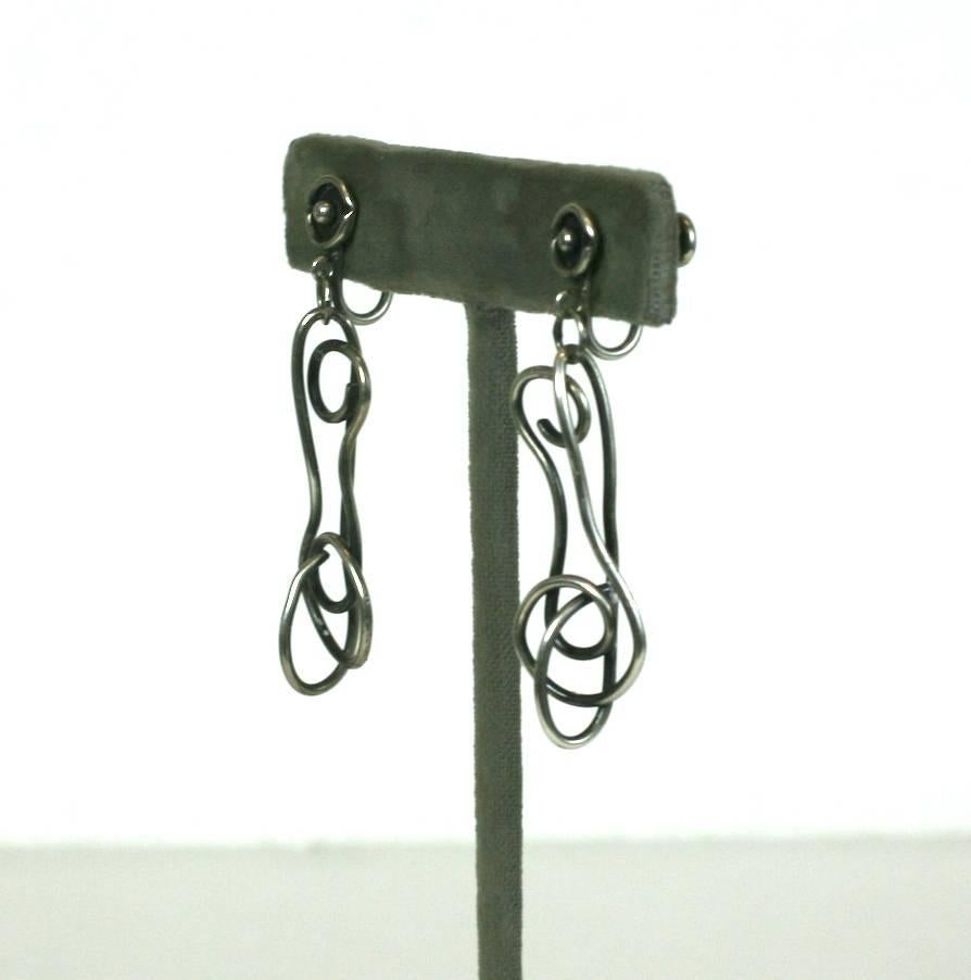 Sterling Artisan Mobile Earrings from the 1950's. Modernist sculpture formed by manipulating sterling wire, hanging from simple posts with screw back fittings. Interesting from every angle. Studio jewelry 1950's USA. 
1950's USA. 2" x