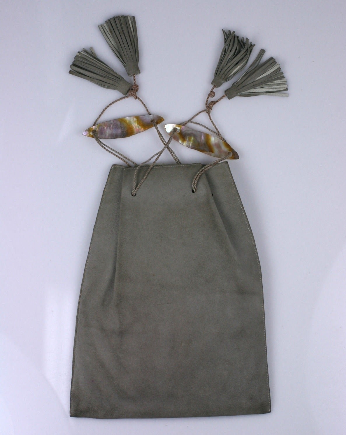 Wonderful Arts and Crafts Dragonfly Pouch in dove gray doe skin with mother of pearl dragonfly inlays. Additional detailing is added through the tooling of the suede in the corners of the pouch.
Typical drawstring closure with the addition of