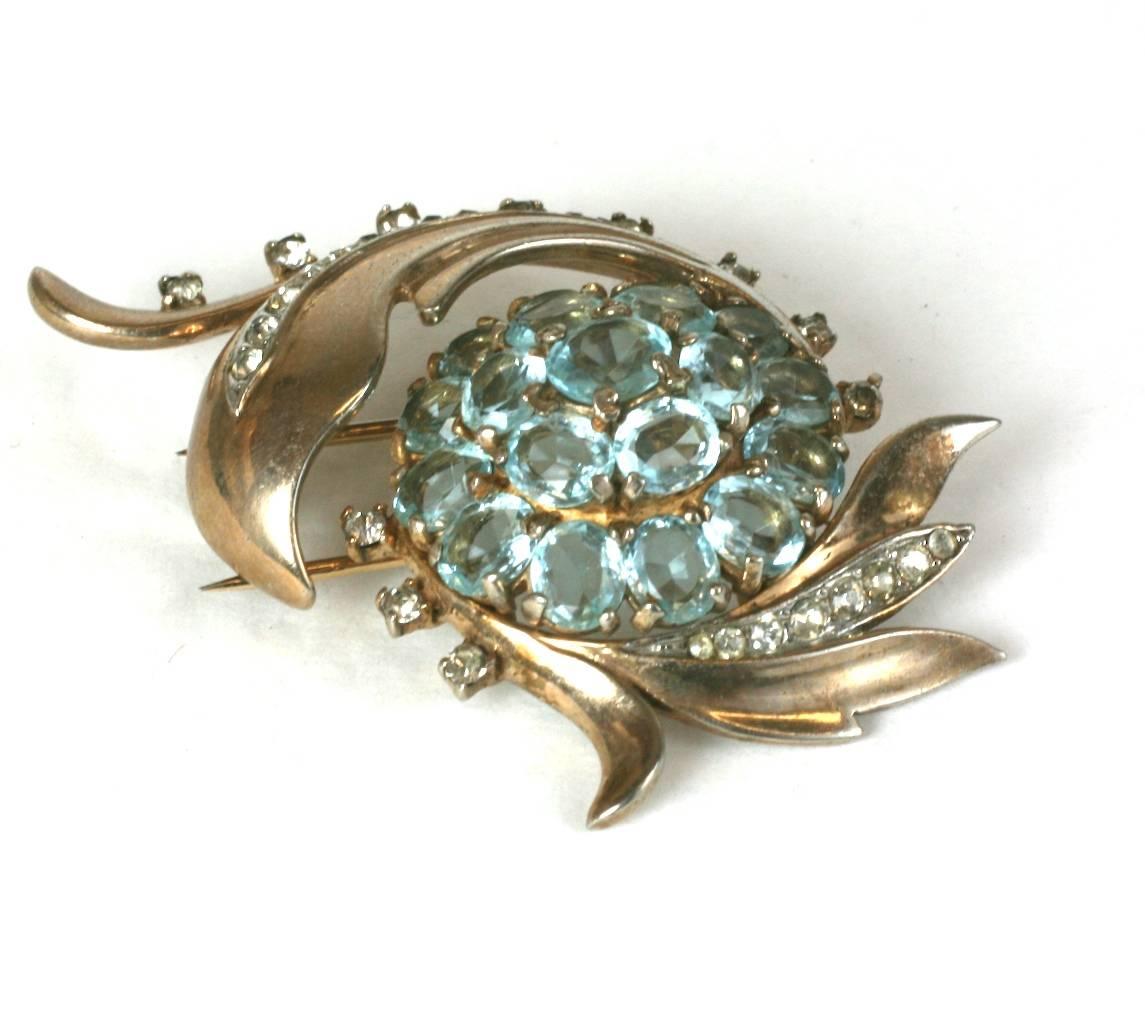 Trifari Alfred Philippe's dimensional gold washed, sterling silver Retro clip brooch. Of pale oval faux aquamarines set in a swirling motif of crystal pave. Clip Back Fittings with safety lock. Excellent Condition. 1940's USA. 
Length 2.50