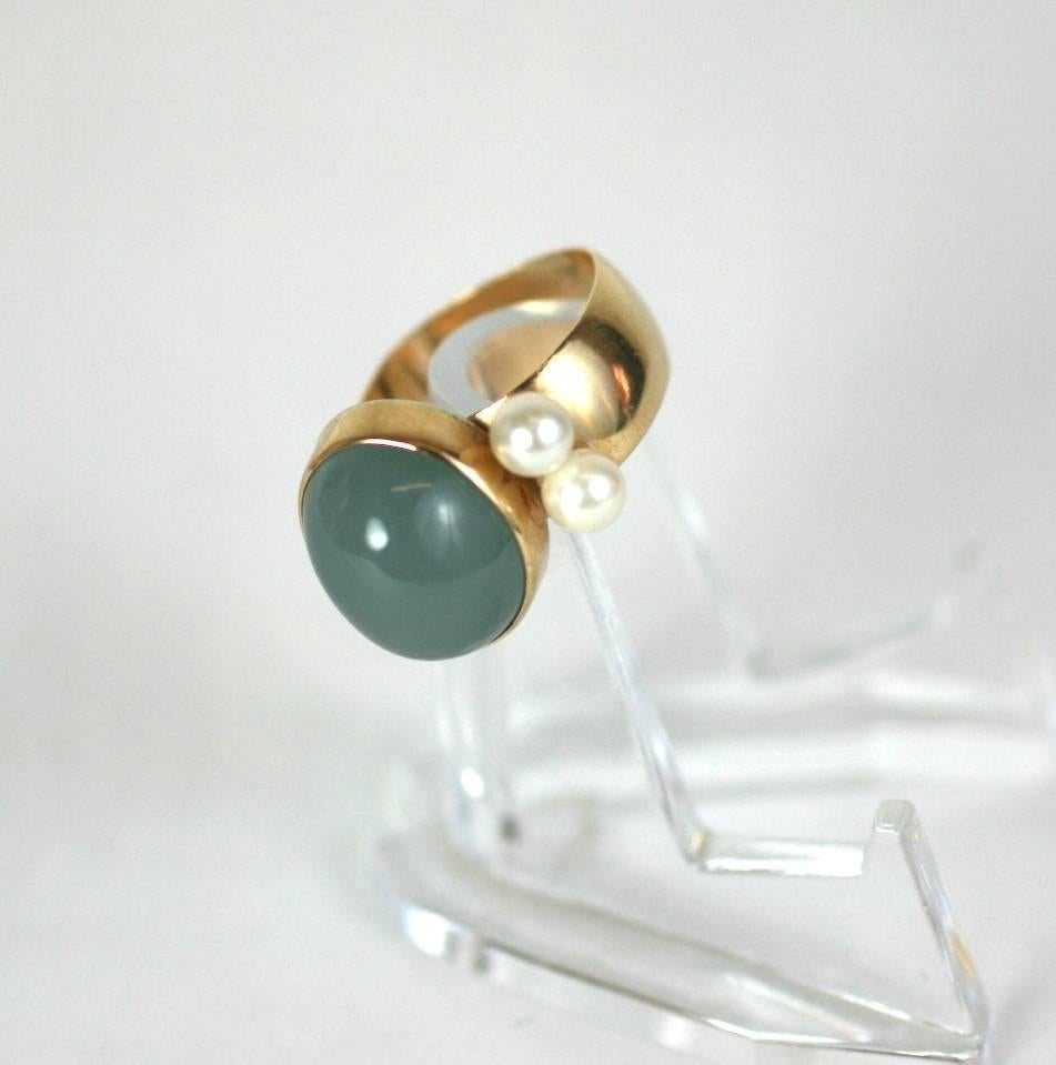 Modernist Chalcedony and Pearl Ring with Chalcedony (or possibly tumbled Aquamarine) cabochon flanked by 2 cultured pearls on a wide, squared off, 14k gold band. 
Bezel set 