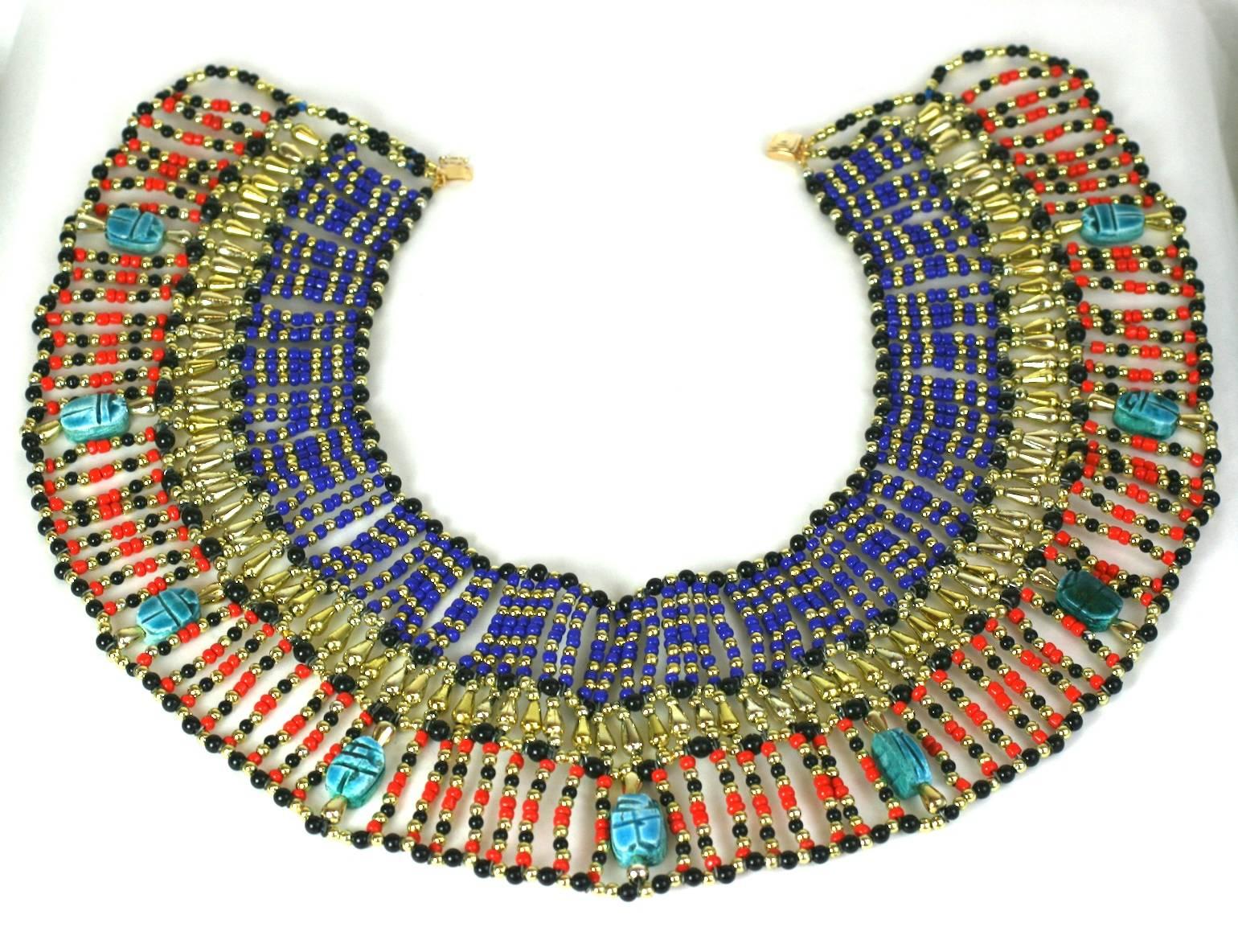 Large Eygptian Revival Handmade Bib from the 1960's. Beads of all shapes and sizes in resin, glass and plastic are used to simulate lapis, gold, coral and jet with genuine faience scarabs. Light in weight due to materials used. 
1960's USA. Gilt