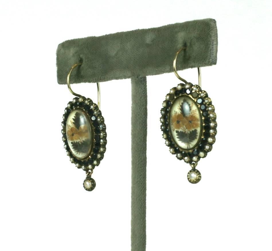Wonderfully Unusual Victorian Memorial Earrings from the mid 19th Century. 
Finely woven hair of different tones have been used as a "fabric" in the design of miniature flower bouquets under glass (likely rock crystal). 
Often hair (both