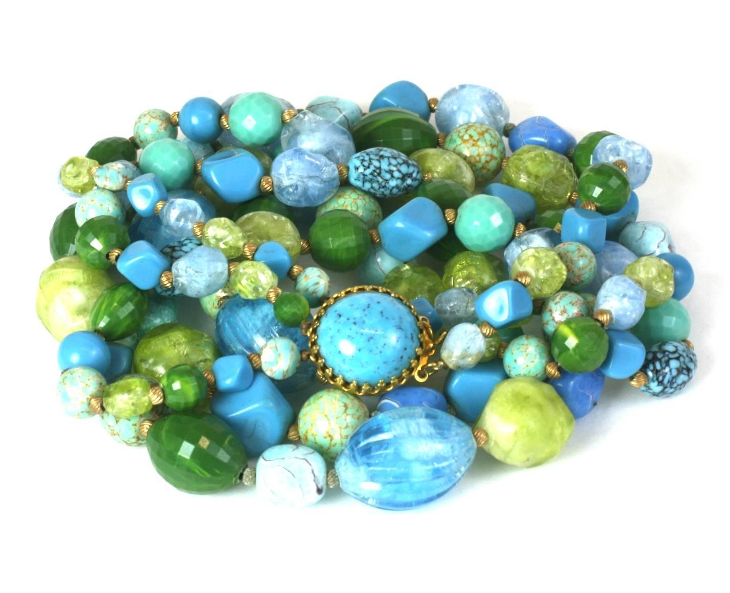 Striking Hattie Carnegie multi strand bakelite and resin bead necklace. The three strands comprised of marbleized avocado, lime, dark and pale turquoise, vari size beads with gilded metal spacers. Signature circular faux turquoise cabochon clasp.