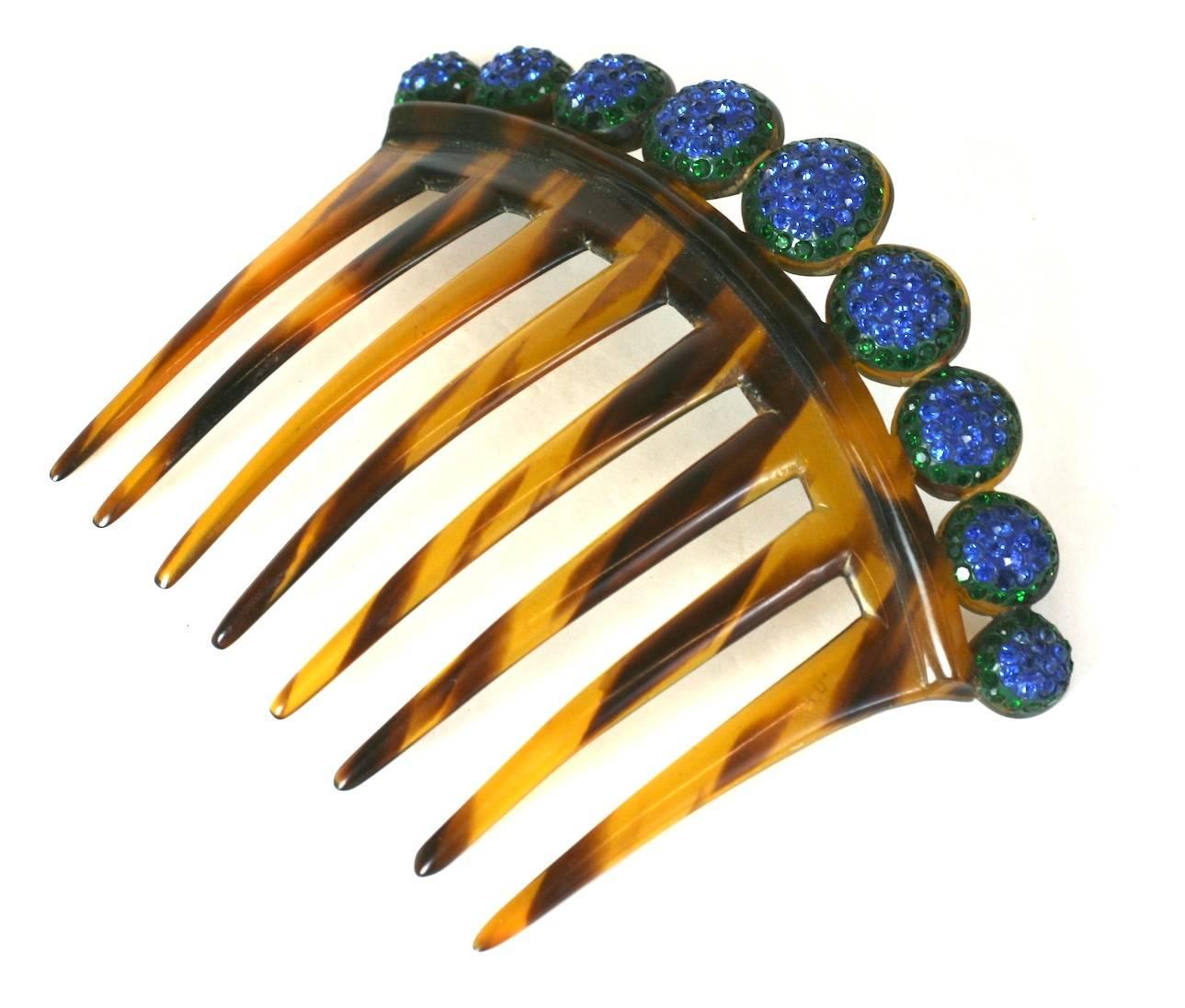 Art Deco Pave Ball Comb form the 1920's. Graduated half spheres are pave set with emerald and sapphire paste stones on top of a faux tortoiseshell comb.
1920's USA. 5" x 4" high.
Excellent condition. 