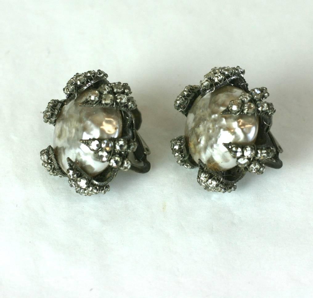 Très belles boucles d'oreilles Miriam Haskell à griffes de perles et de roses datant des années 1950. Une grosse fausse perle baroque est retenue par des 