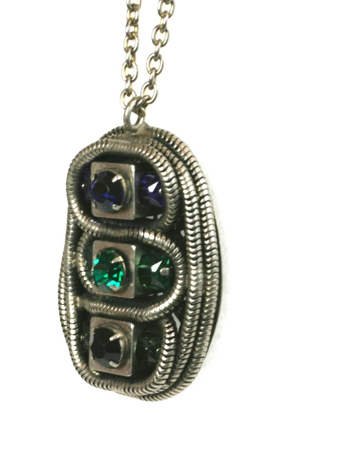Yves Saint Laurent Early Pendant by Scemama 1970's. Striking design with vari cut stones in deep blue, emerald and jet layered within a pendant built up from coiling snake chaining and fitted onto a filigree base. There are square cut stones nestled