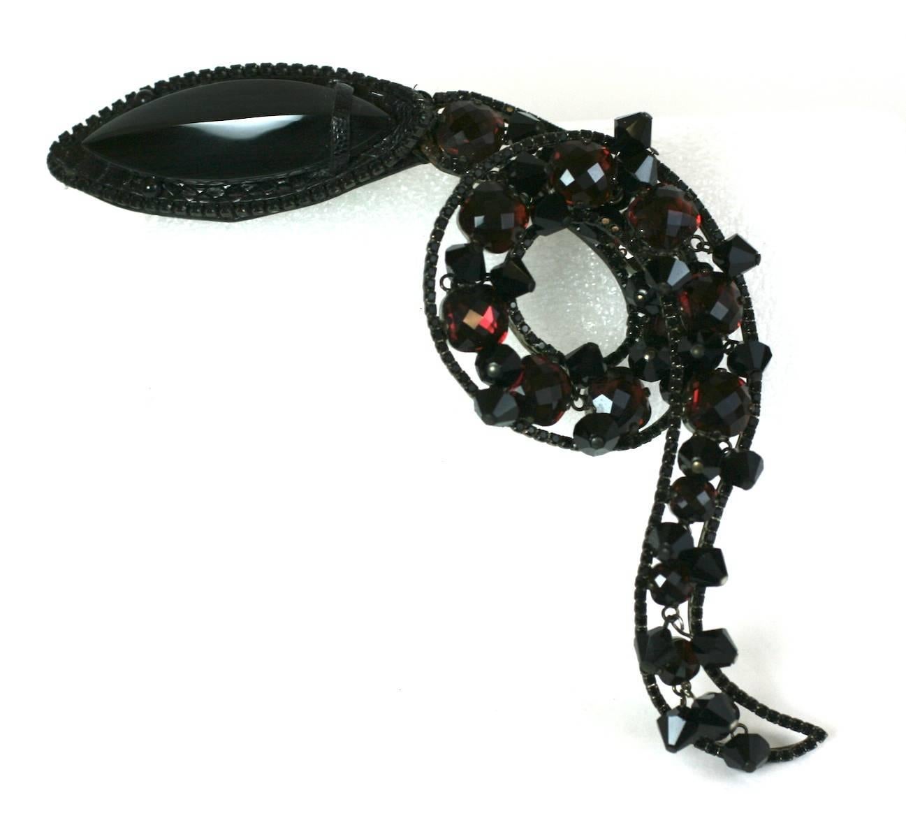Amazing Haute Couture Valentino Snake Brooch from the 1980's. Completely hand made, with an ornate curled setting of miniature jet pave, rose cut amythest crystals all set onto a base of shiny black snakeskin.
The head is a large marquise shaped