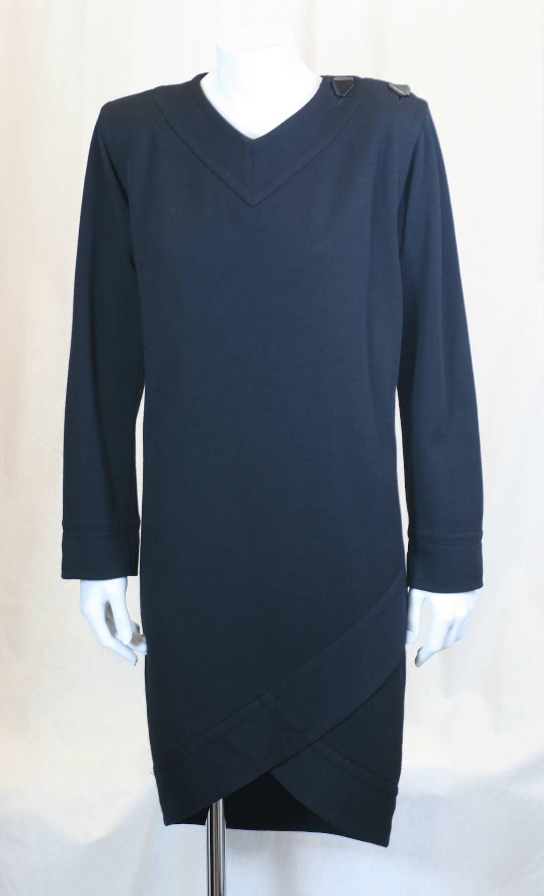 Yves Saint Laurent Black Jersey Faux Wrap Dress with strong shoulders and slim straight cut.
2 button closure at shoulder and faux wrap detail at dipping hem. Wool jersey double knit with
silky lining. 
Small hole on top left shoulder, see image.
