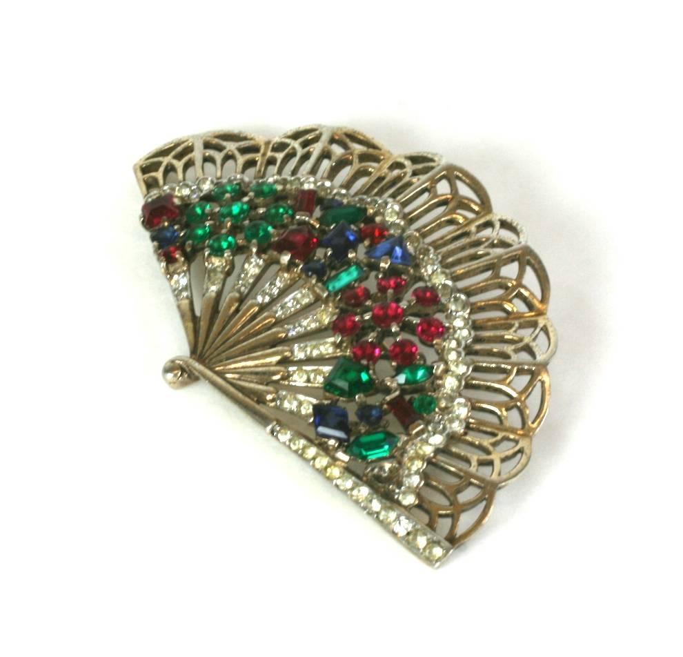 Trifari by Alfred Philippe gilded sterling silver open work fan brooch from the 1940's. 
Faux vari cut ruby, emerald, and sapphire gems are set in vermeil sterling silver. 
Excellent condition. 
Length  2.75"
Width 1.75"