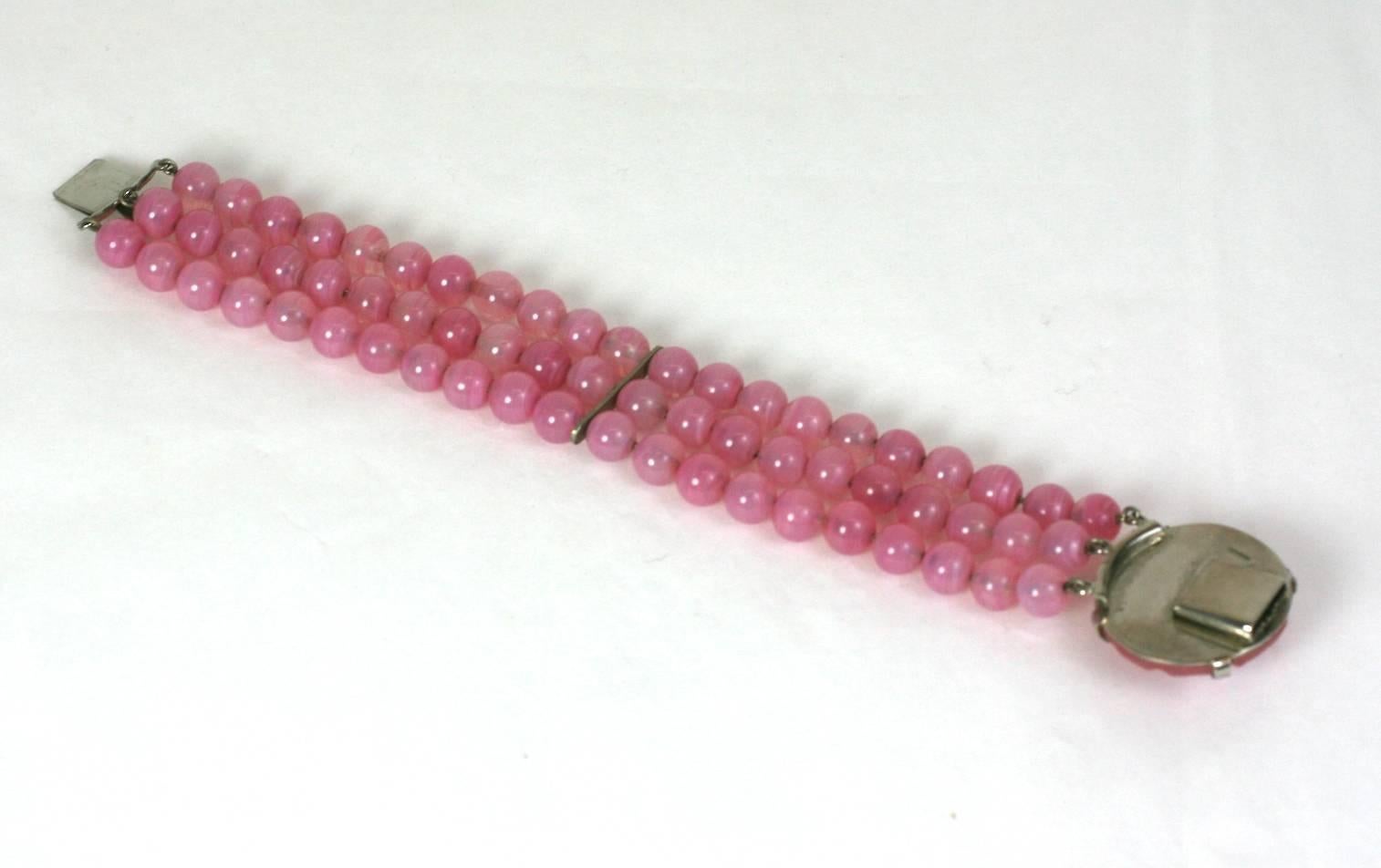 Louis Rousselet faux rose quartz pate de verre bracelet. Three strands of hand made beads terminate in a large pate de verre naturalistic floral cabocheon.
Marked Depose. France 1930's. 
L 7.50