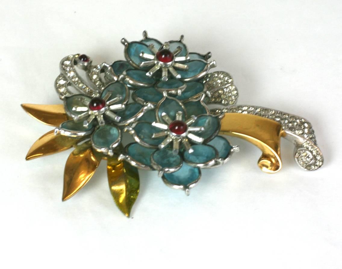 Pennino Retro floral spray brooch of gold plated metal and rhodium  finish. Dynamic design set with bezel set faux oval faceted aquamarines and ruby bullet cabochons with crystal pave accents. Signed Pennino, 1940's USA. 
Excellent Condition. 
L 3