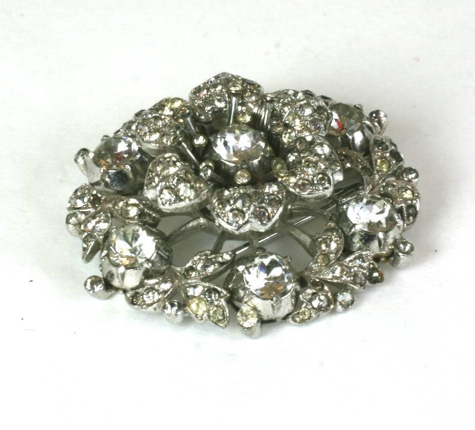 Trifari Alfred Philippe Georgian style Regence clip brooch with pave tremblant flower and garland surround. Set in rhodium metal and designed to look like antique mine diamonds en tremblant.  Pave flowerhead is set on a spring and moves gently with