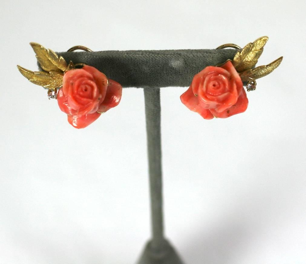 Lovely Carved Coral Rose Earclips by Erwin Pearl in 18k gold with diamond accents. Deeply carved natural coral roses are framed by a pair of finely etched leaves and a single diamond on each earring.  Clip back fittings. 
1960's USA.  1.5" x