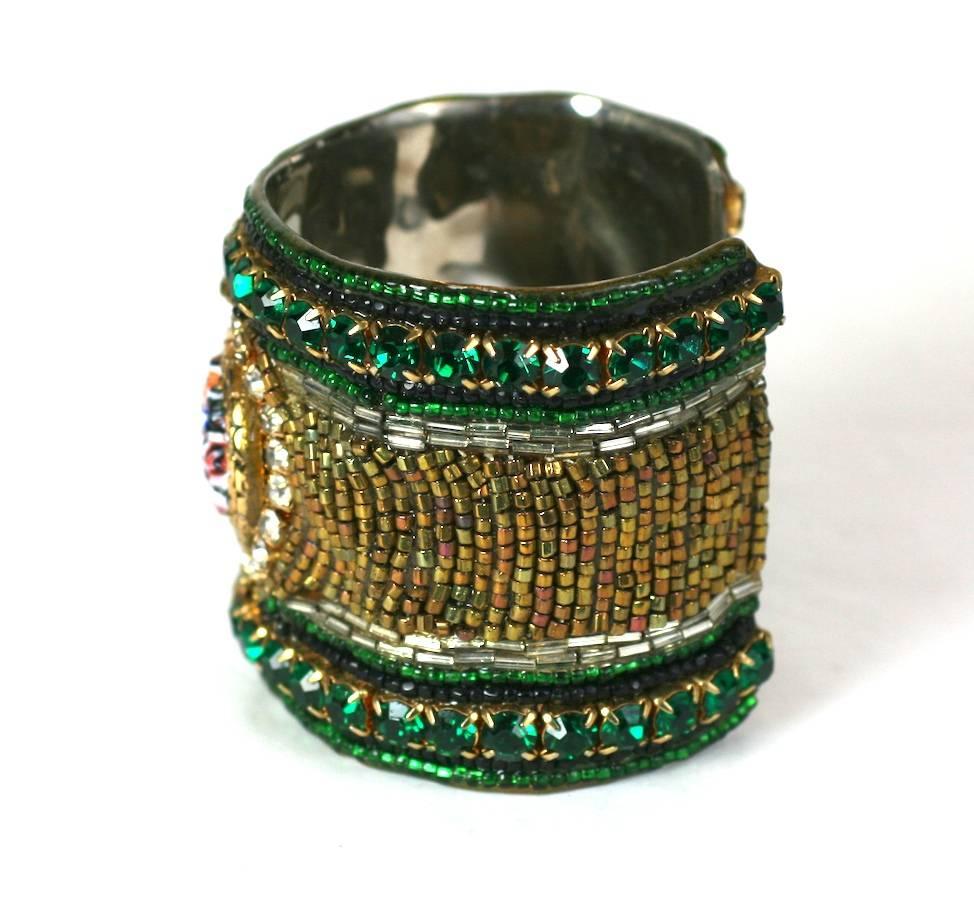 1980's Mixed Media Beaded Cuff composed of crystals, seed beads with a central Murano glass cabochon in tones of emerald and copper. 
2.5