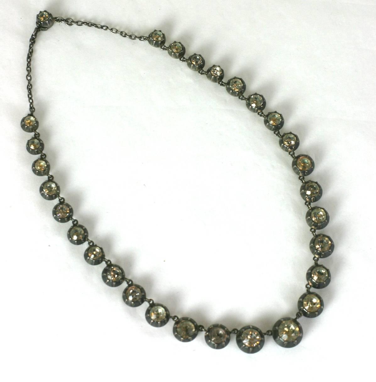 Georgian Paste Riviere Necklace set in silver. Early 18th Century manufacture with period closed back settings and faceted foil backed pastes. Graduated riviere configuration with a period chain extension. Sterling silver 1820's UK. 
Excellent