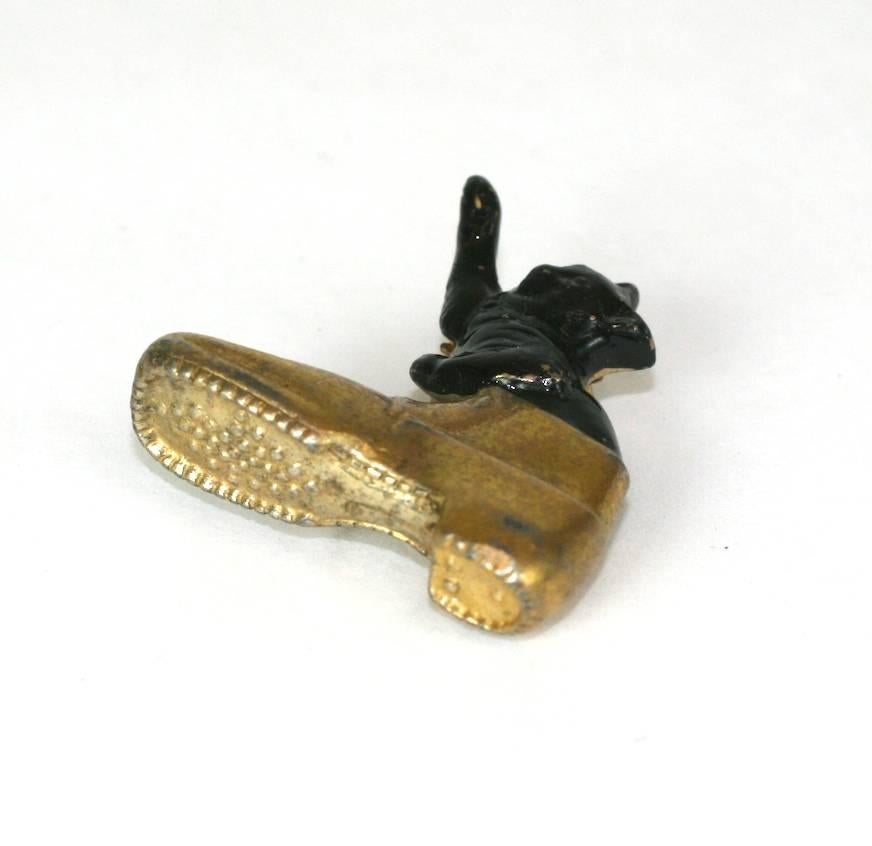 Playful boot residing kitten fur clip brooch of cold painted black enamel and gilt brass. 
Clip back brooch fitting. Charming 1930's novelty jewelry.
Excellent Condition.
 Length 1 3/16"
 Height 1 1/8"