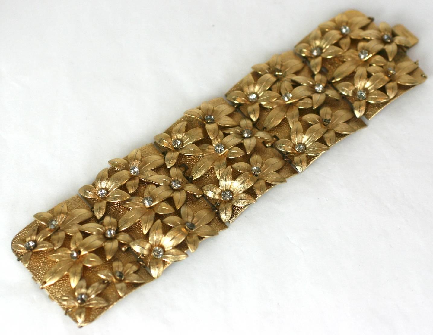Napier gilt, five paneled cuff bracelet of rich textured metal embellished with trembling flower heads and prong set crystal pastes. Box clasp and safety chain. 1950's USA.
Excellent Condition.
L 7 1/8