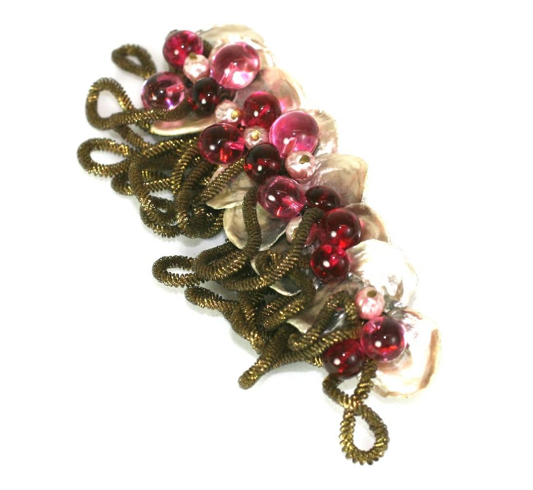 Large Louis Rousselet unusual and elaborate bar brooch. Of signature gilt filigree with floral inspired decorations composed of unusual nacre petals, ruby pate de verre beads, faux pearls and loop fringed gilt military braid. 1930's France.