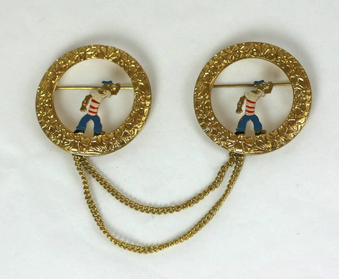 French Twin Popeye character brooches, of gilt metal connected by chain swags. Figures are further decorated with finely painted cold enamel. 1930's France.
Excellent Condition. 
Width 1.50