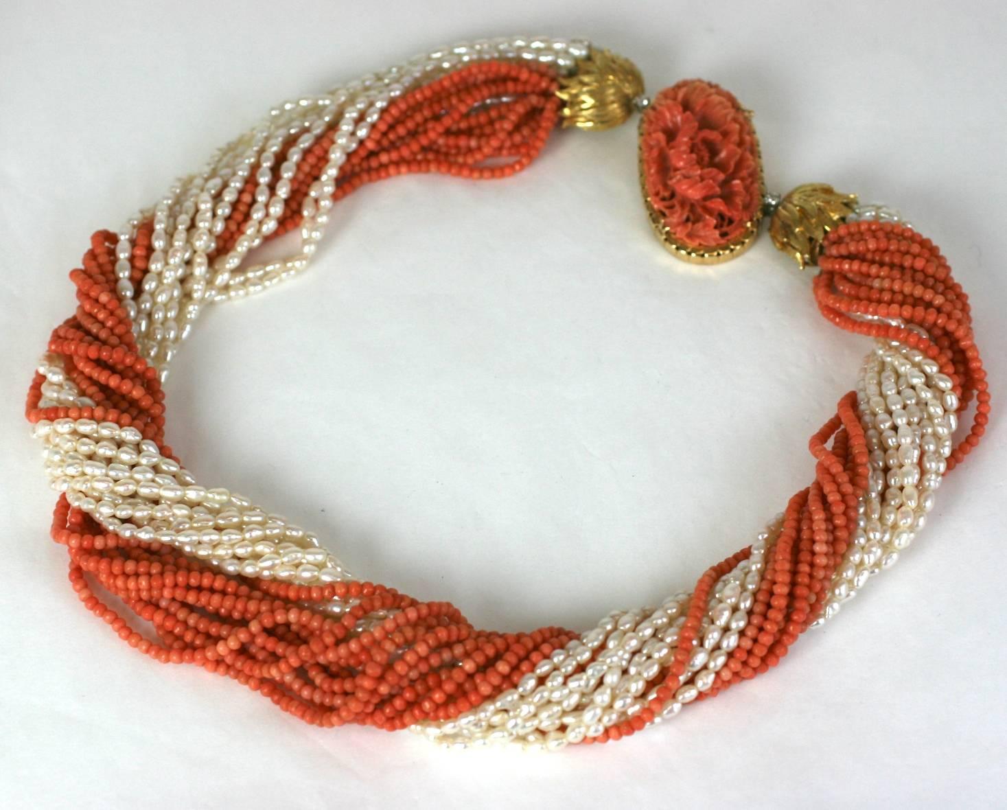 Elegant and attractive Carved Coral and Rice Pearl Torsade Necklace circa 1960's. Custom ordered design with finely carved coral crysanthemum panel (antique) set in an heavy 18k gold clasp. There are 18k gold foliate hilts which hold the beads with