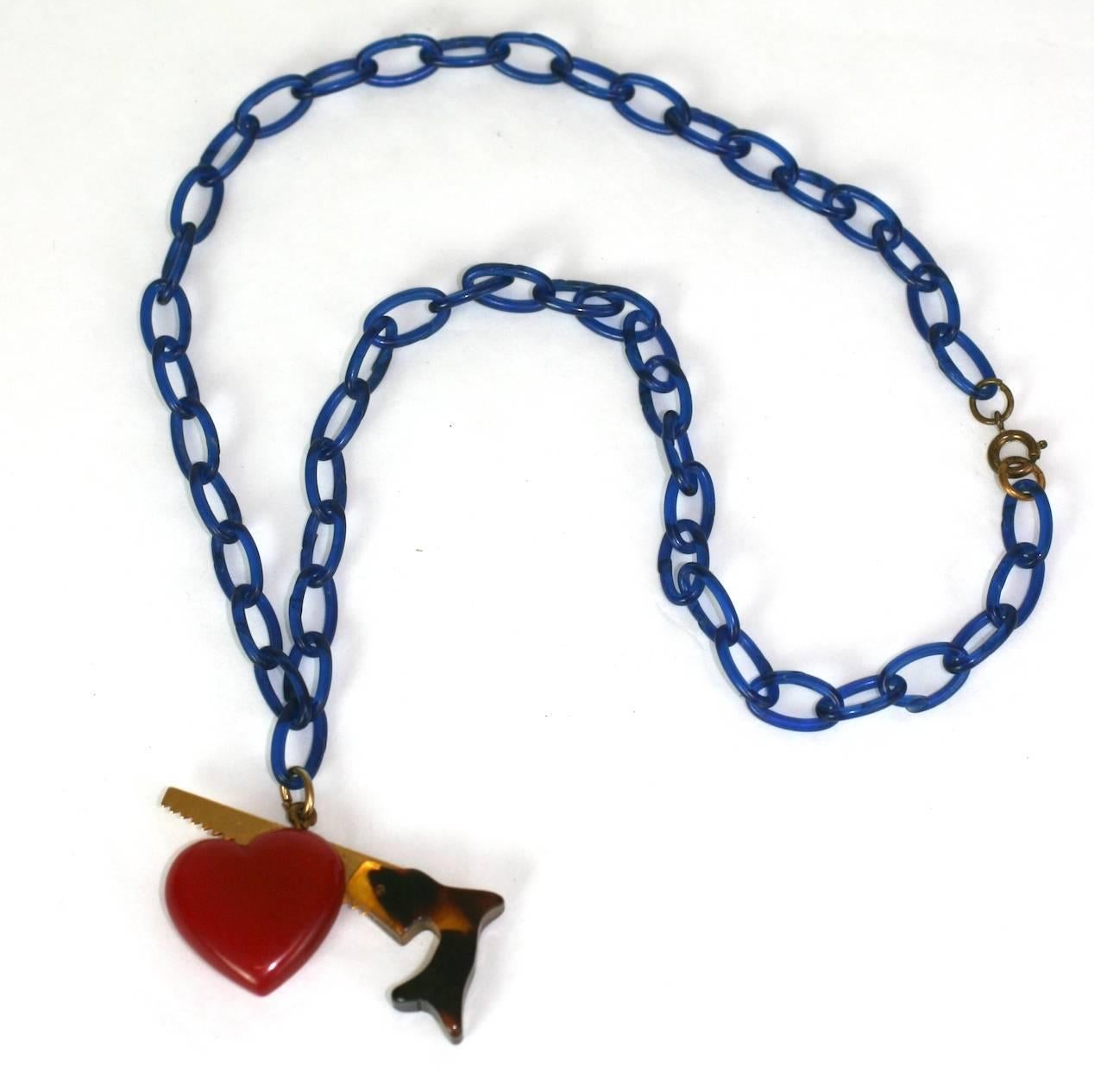 Rare and special Bakelite breaking heart pendant necklace from the 1930's. Composed of finely detailed red and mottled tortoise shell colored bakelite and gilt metal. Suspended from a vivid blue celluloid chain. Sadly, the breaking heart is actually
