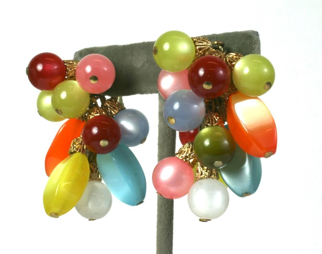 Napier Moon Glow Berry Cluster Ear Clips from the 1960's. Colorful beads of spun nylon give off a special reflection similar to cats eye stones. Clip back fittings.
Fun and striking pastel tones, with gilt filigree caps. 2