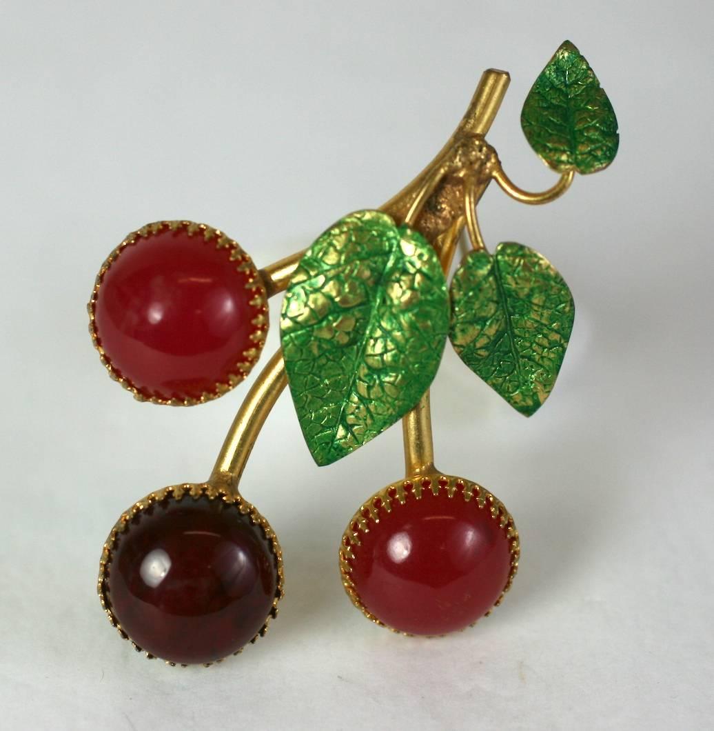 Charming Cis Cherry Brooch from the 1950's. 
2 tones of bakelite cherries are set into signature Cis gilt crown settings with enameled leaves. 
France 1950's, by Countess Cis, Unsigned. 3.5