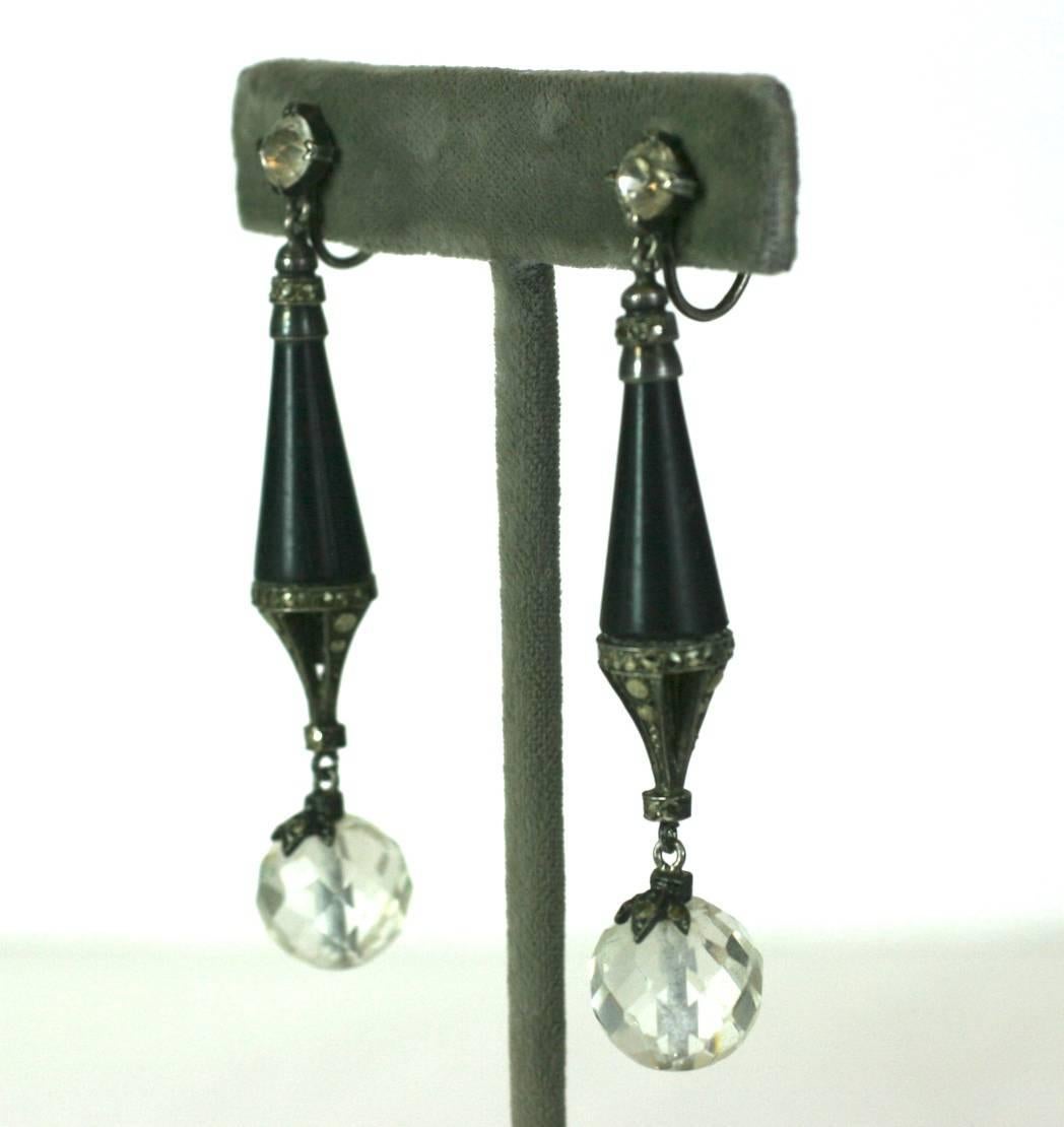 Unusual French Art Deco Marcasite and Rock Crystal Earrrings from the 1920's. An openwork matte black enamel tear drop is set with marcasites and falls from a single paste on the ear. 
Each earring has an additional faceted rock crystal drop set