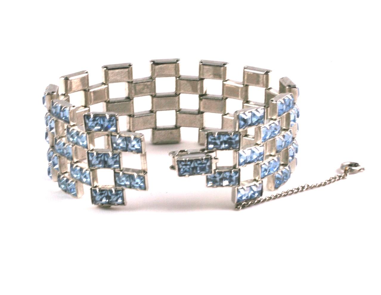 Unusual channel Set Faux Aquamarine Paste Bracelet from the 1950's USA. Pairs of channel set square cut pale blue pastes are set into an articulated wide link formation. 
6.75